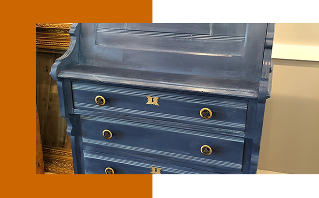 A blue dresser with two drawers and a mirror.