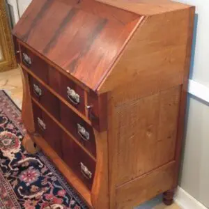 A wooden desk with drawers and a small cabinet.