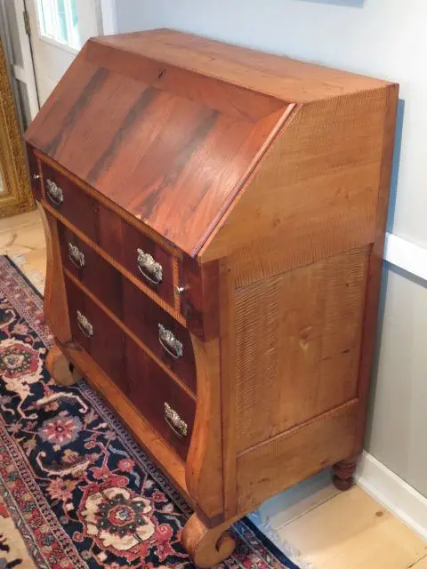 A wooden desk with drawers and a small cabinet.