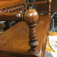 A wooden bench with a ball on top of it.